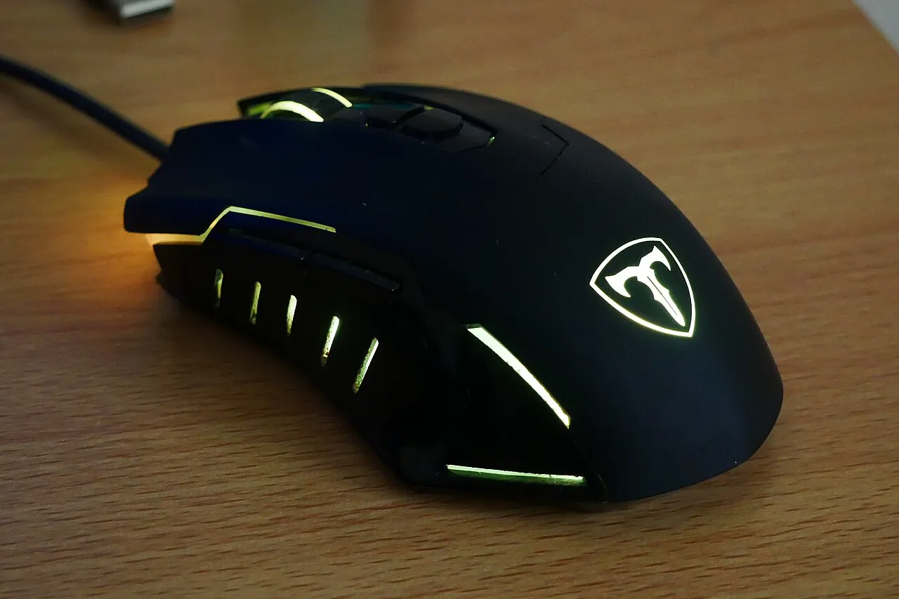 Black gaming mouse photographed on a wooden desk